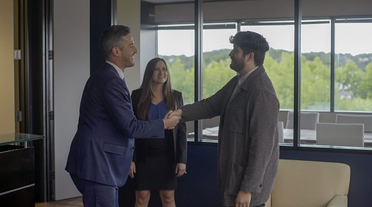 A satisfied client shaking hands with Zinda Law Group attorneys